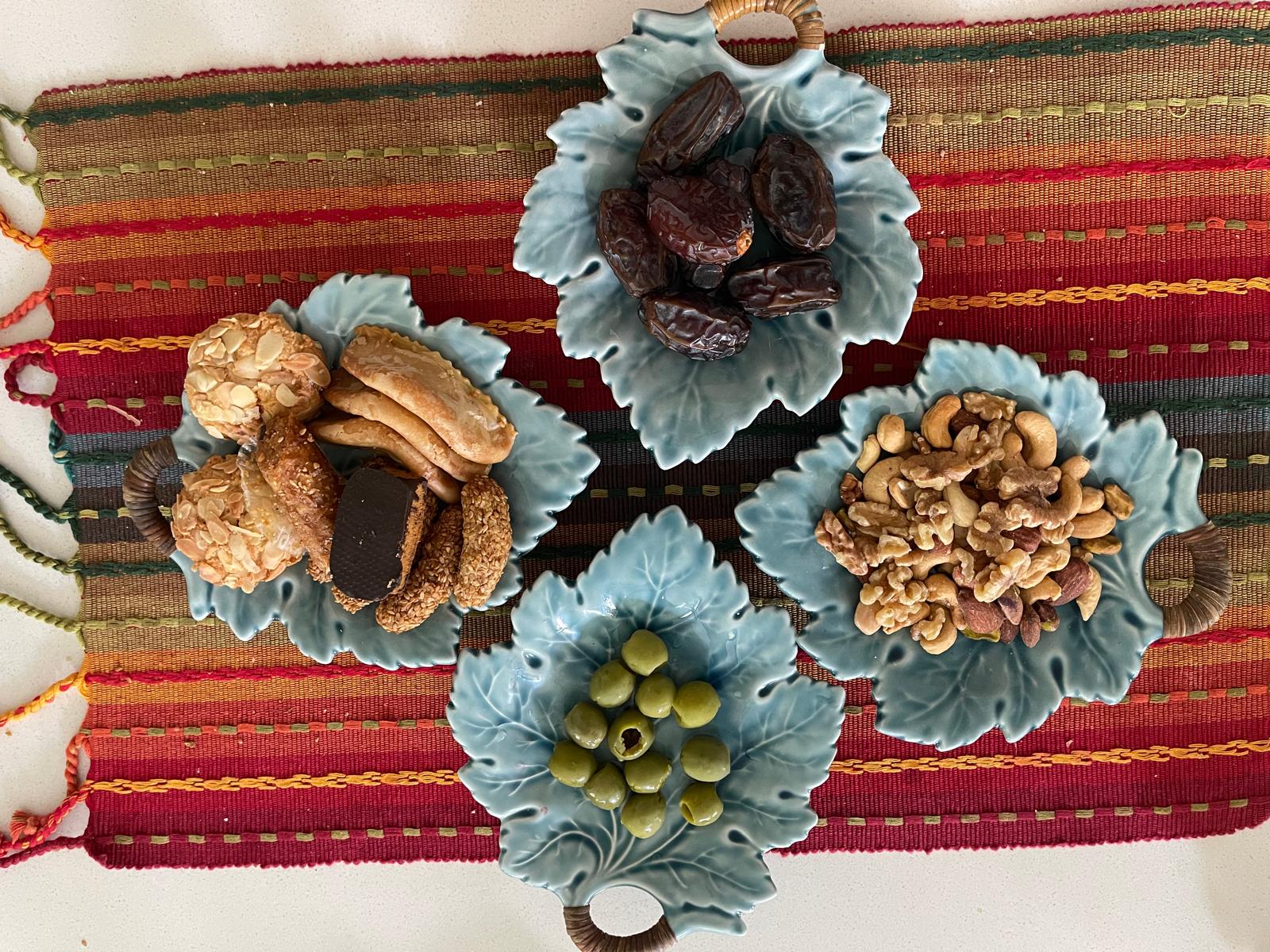 Moroccan holiday cookies — ghribia gazelle horns sesame cookies on blue leaf plate